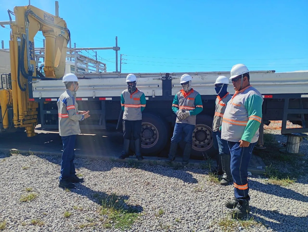 Equipe reunida para diálogo de segurança junto ao caminhão munck
