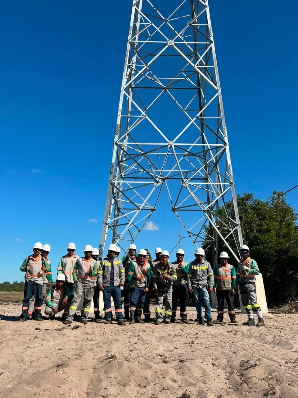 Equipe da FMC em frente a uma torre de transmissão